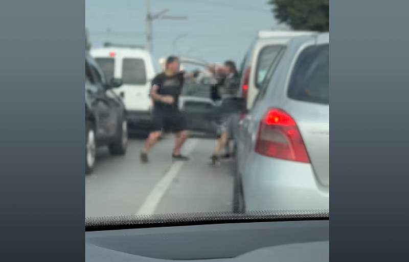 се вижда как на червен светофар изнервен мъж напада шофьор